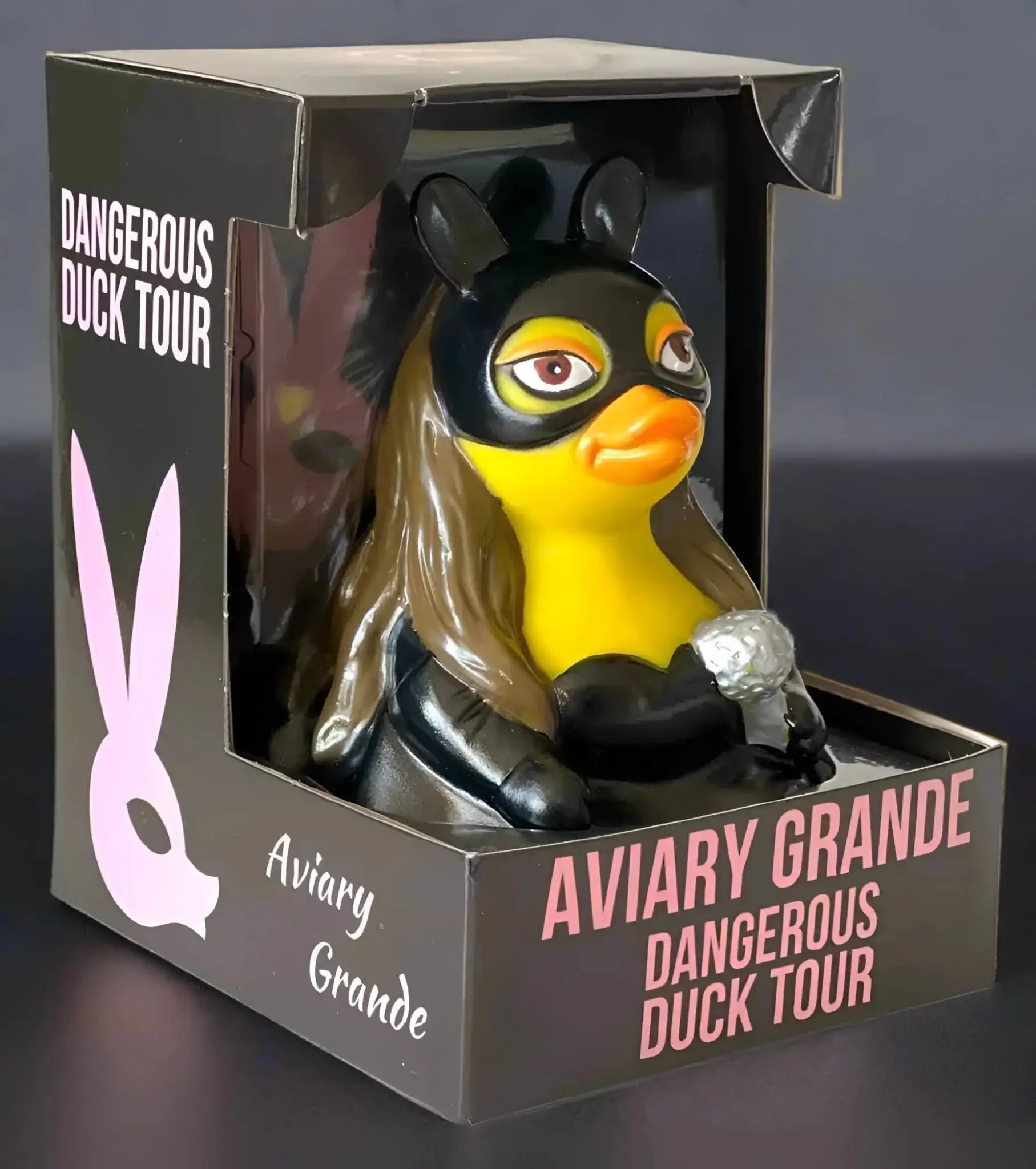 Gelbe gummiente mit schwarzer maske und langen braunen haaren im schwarzen outfit mit silberarmband von celebriducks