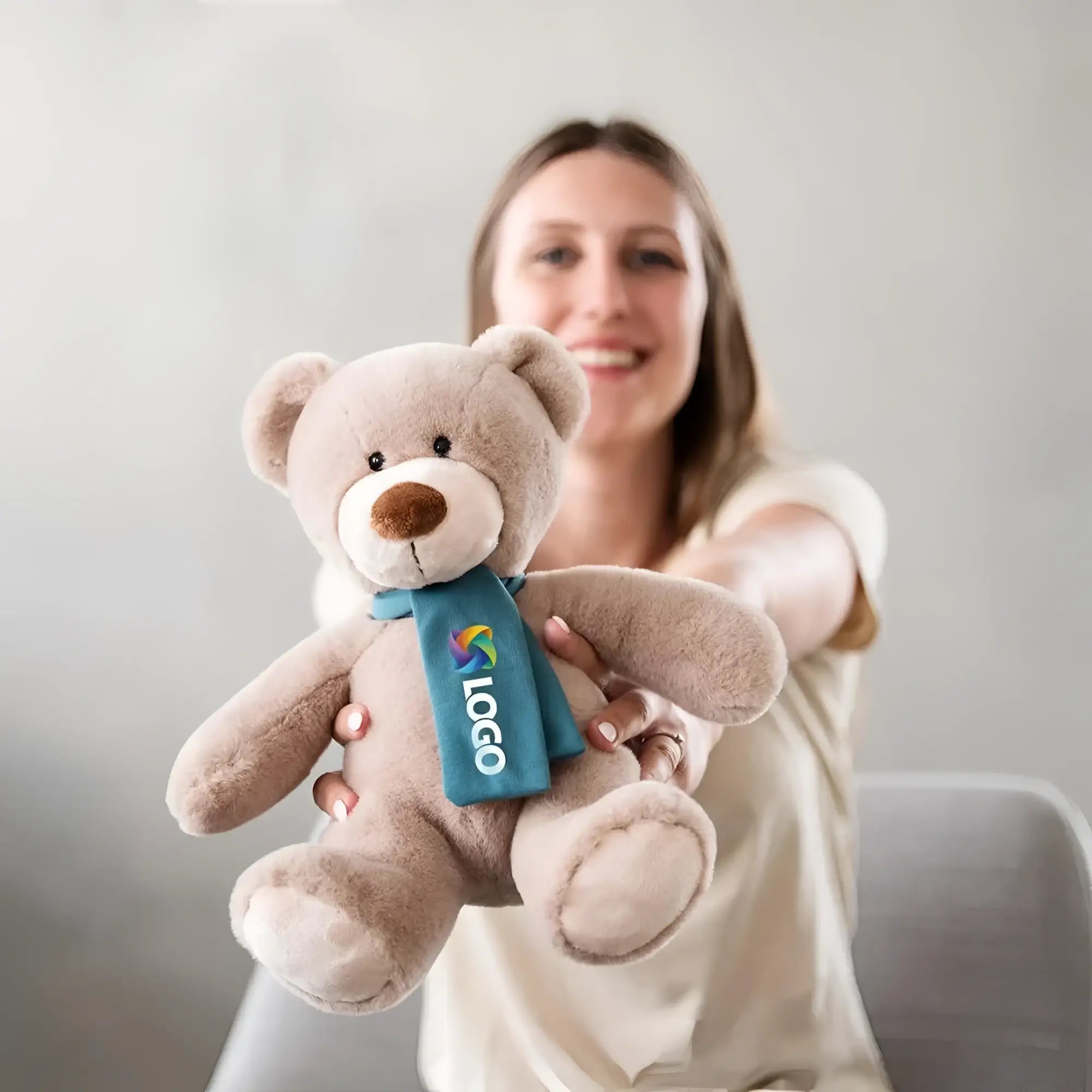Weiches taupe plüschtier bär nanna mit teal schal und buntem logo stofftier teddy fürs kuscheln
