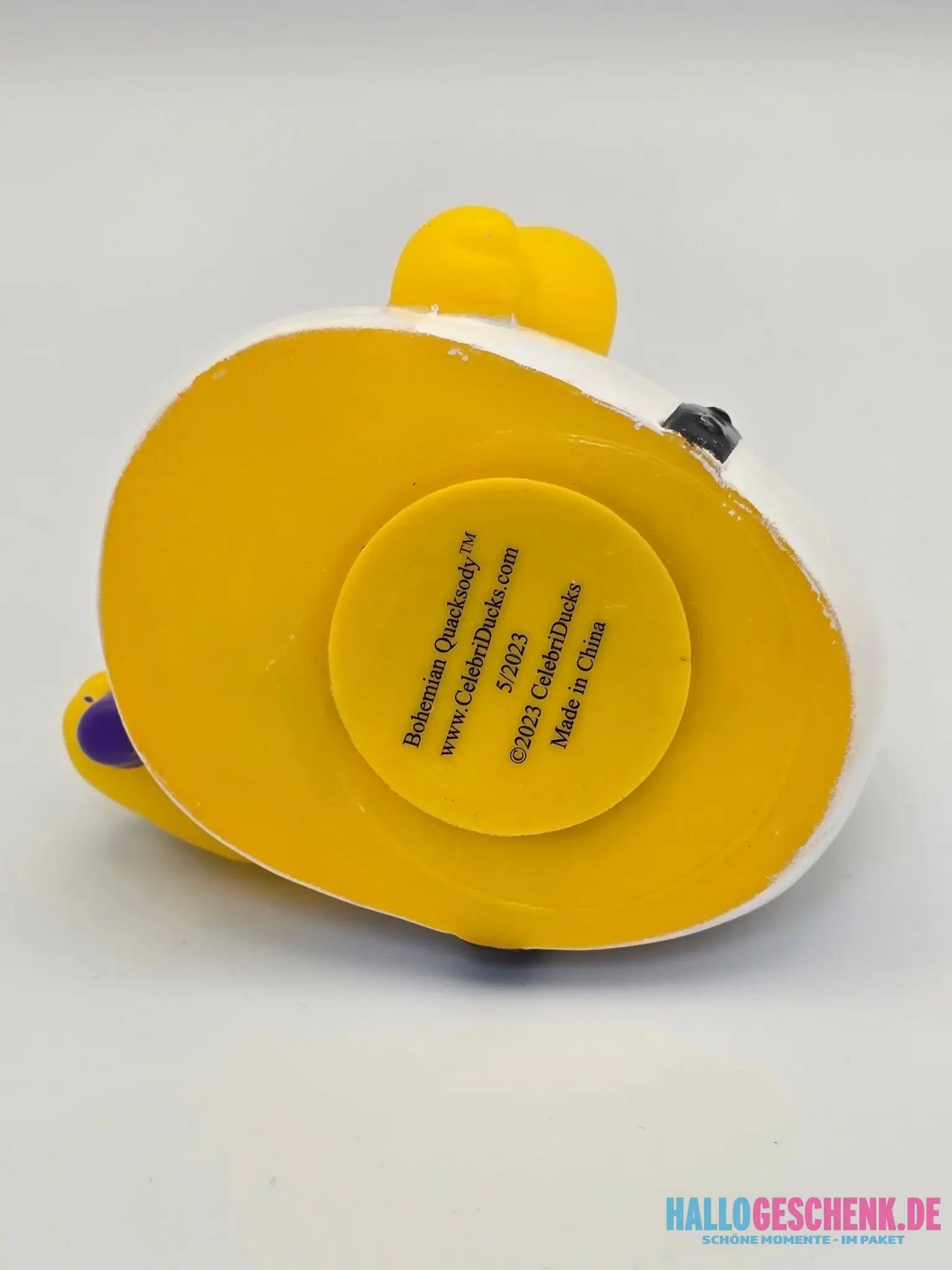 Gelbe und weiße gummiente bohemian quacksody mit rundem label auf der rückseite von celebriducks
