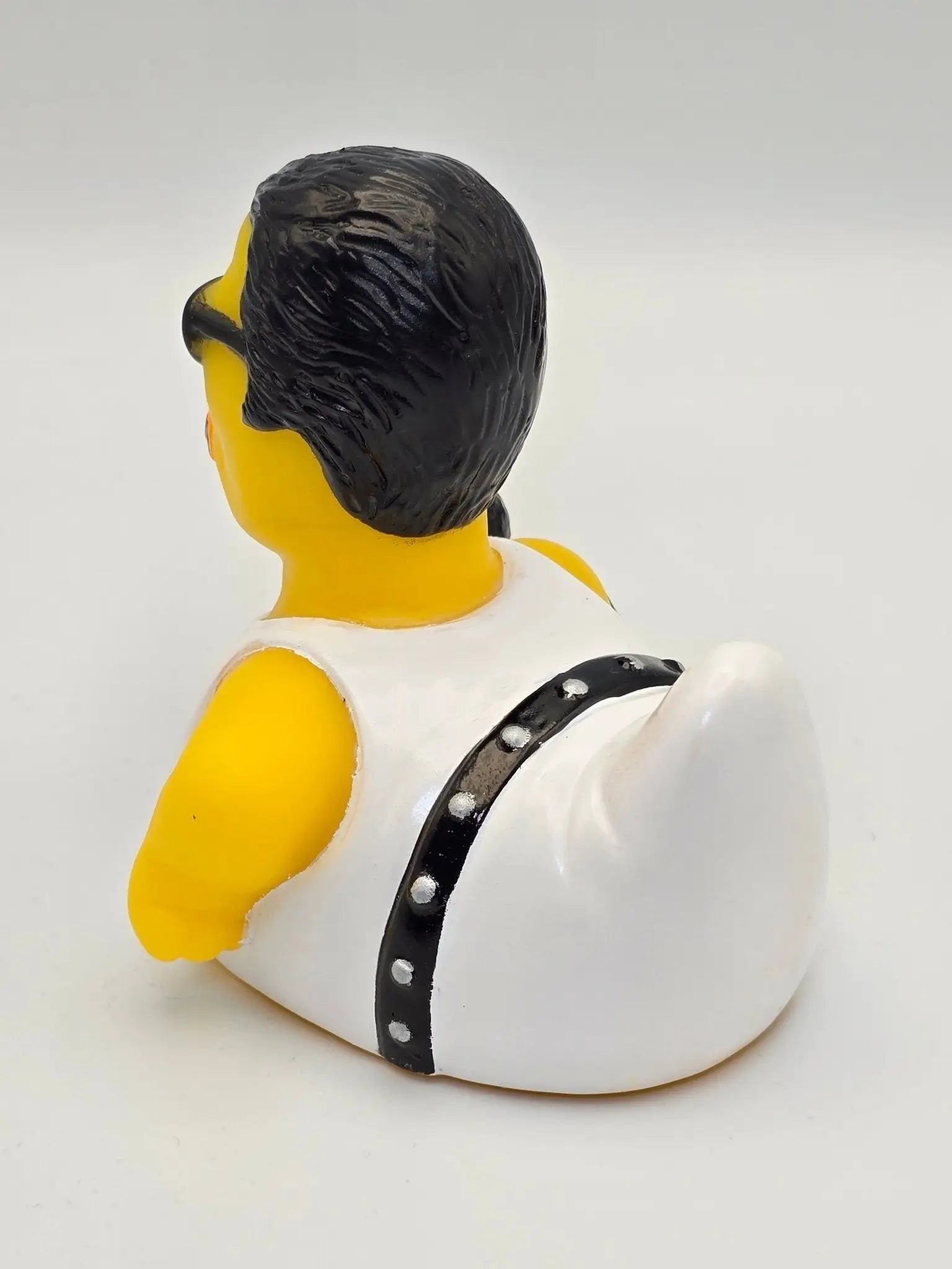 Gelbe gummiente mit schwarzer frisur, sonnenbrille und weißer weste mit nieten schwarzem gürtel bohemian quacksody
