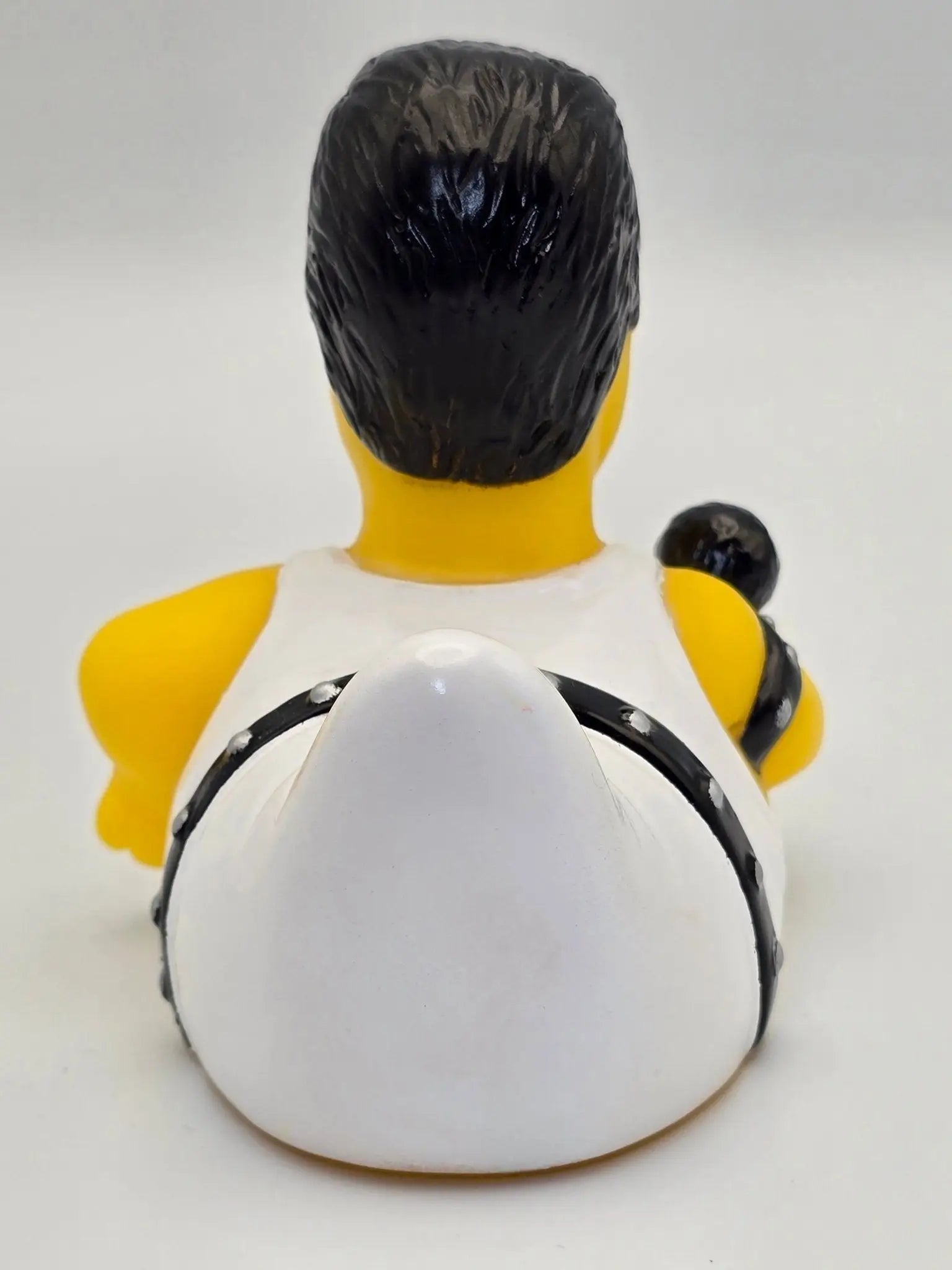 gelbe gummiente mit schwarzen haaren in weißer weste mit schwarzen riemen und silbernen nieten im bohemian quacksody style