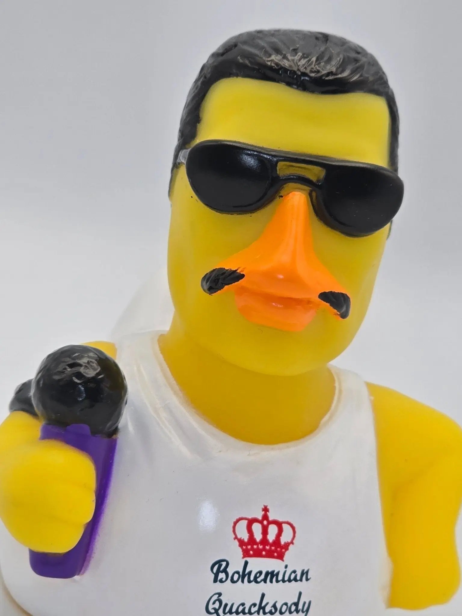 Gelbe gummiente mit schwarzen sonnenbrillen und schnurrbart trägt weißes tanktop mit bohemian quacksody logo von celebriducks