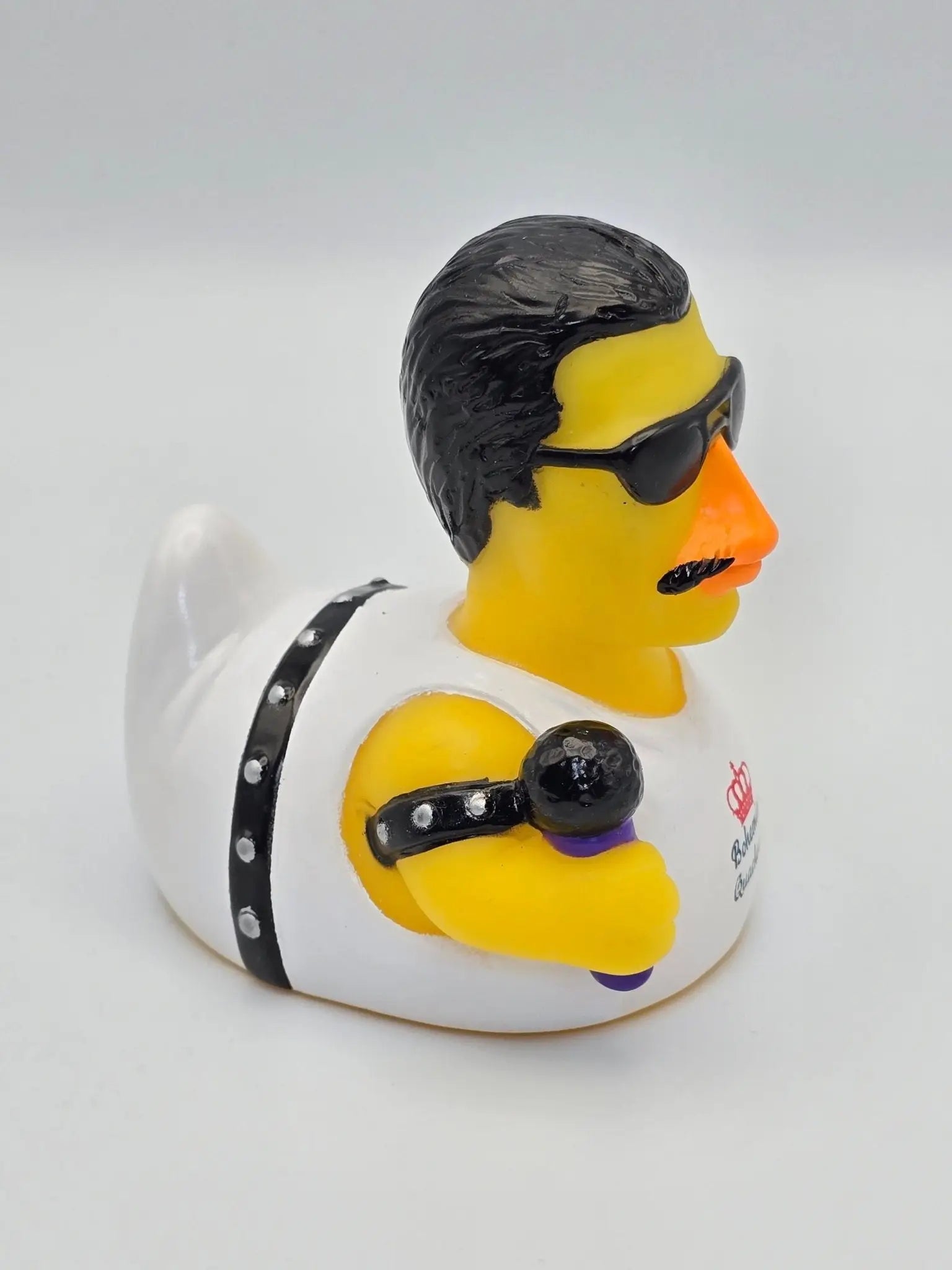 Gelbe gummiente bohemian quacksody mit schwarzem haar, sonnenbrille, schnurrbart, weißem outfit und mikrofon von celebriducks