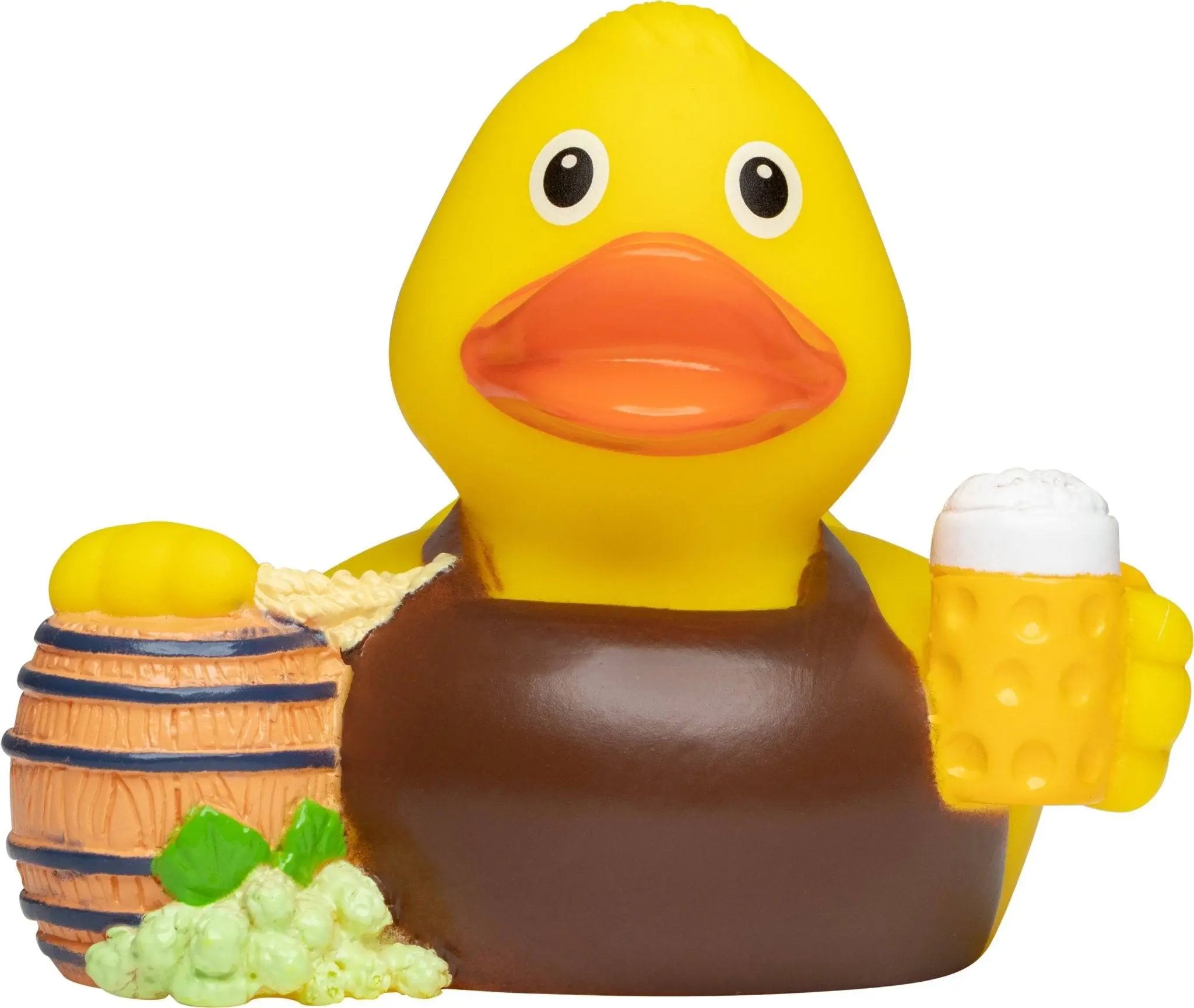 Gelbe quietsche-ente mit braunen overalls hält bierkrug neben mini-fass mit trauben für oktoberfestspaß