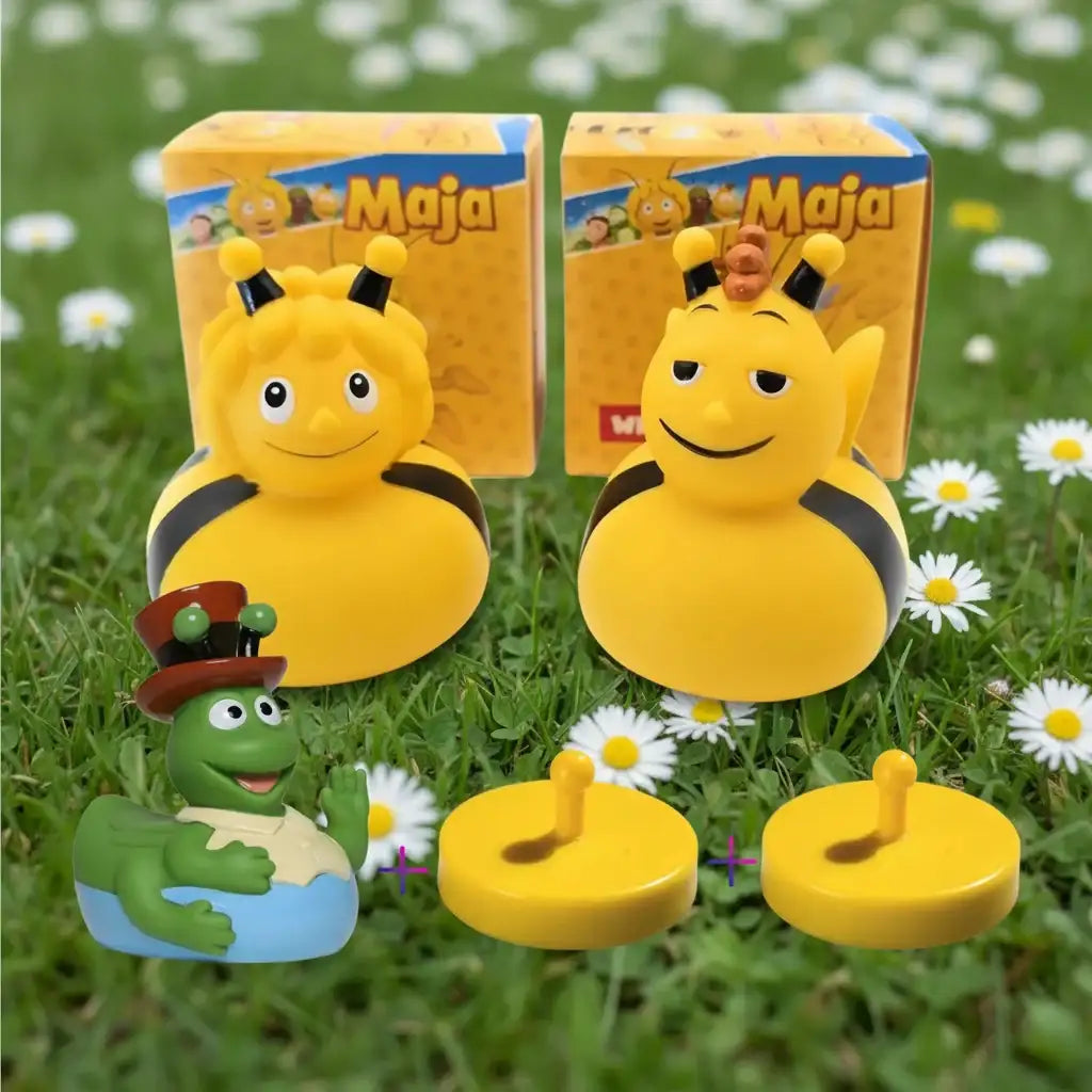 Gelbe gummiente biene maja badeente mit schwarzen streifen und lächelndem gesicht in maja verpackung