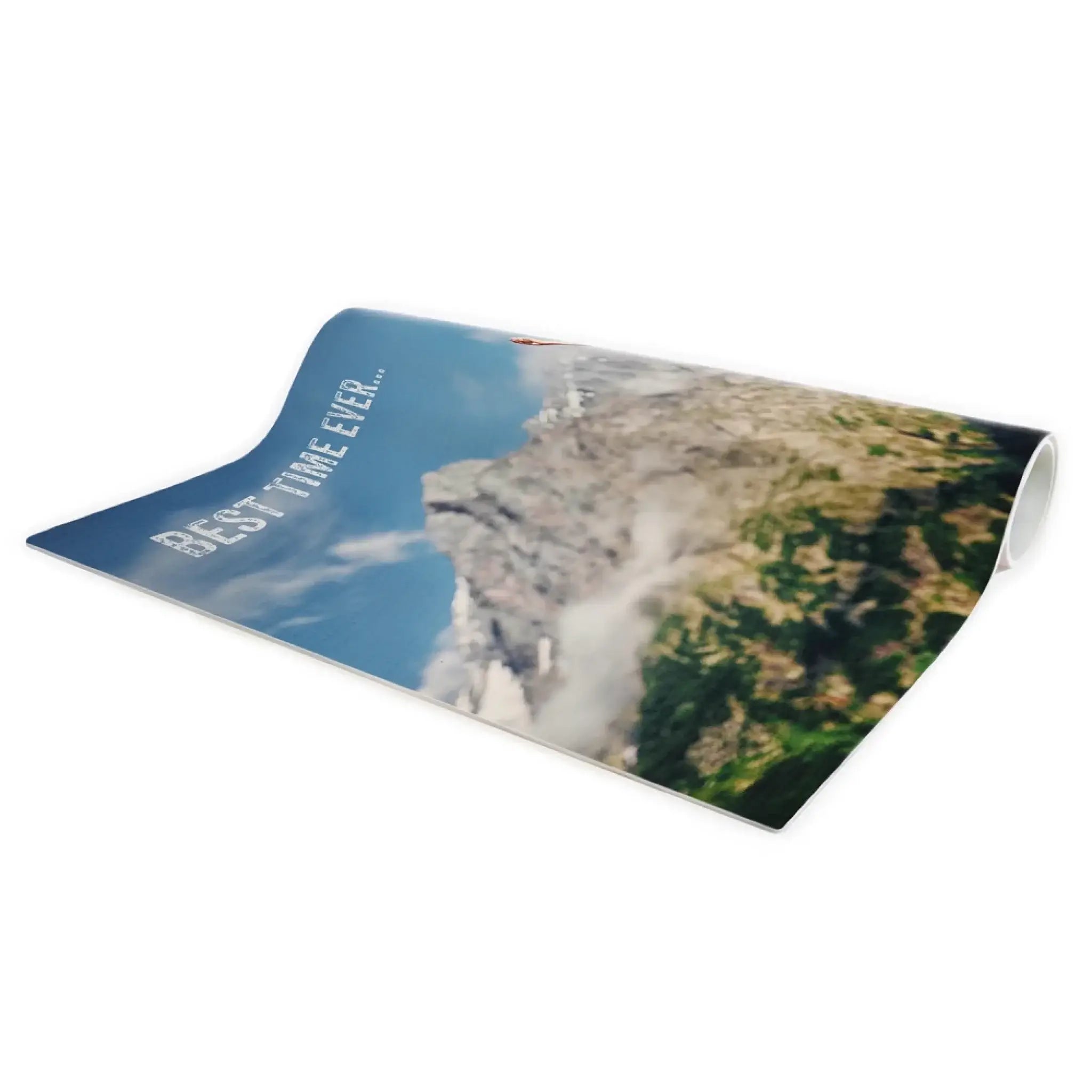 Ein rechteckiges, aufgerolltes mattenprodukt mit bunt bedruckter berglandschaft und text best time ever aus der geburtstag motiv 2 kollektion