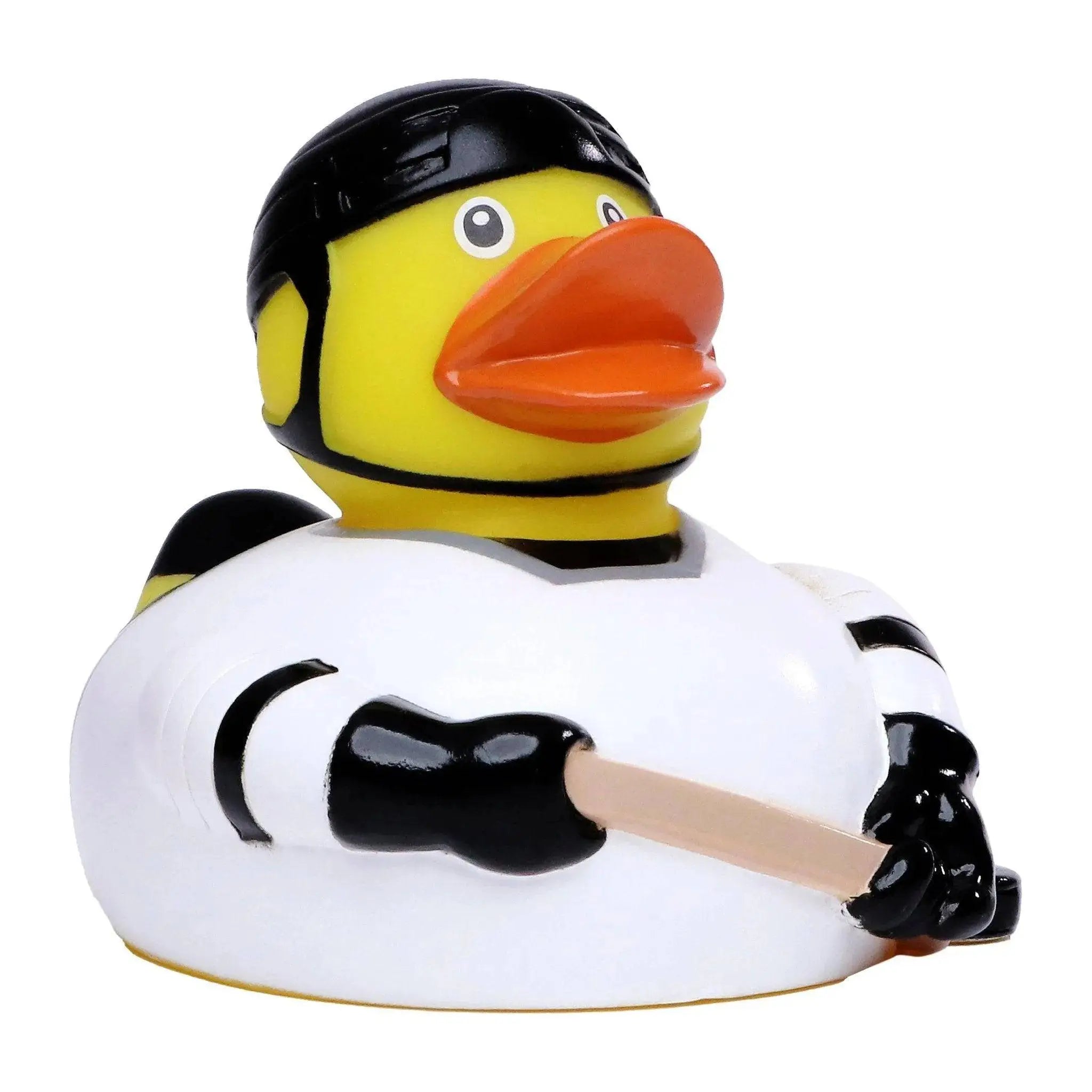 Eine gelbe quietscheente als eishockey spieler mit schwarzem helm und weißem trikot mit schwarzen streifen