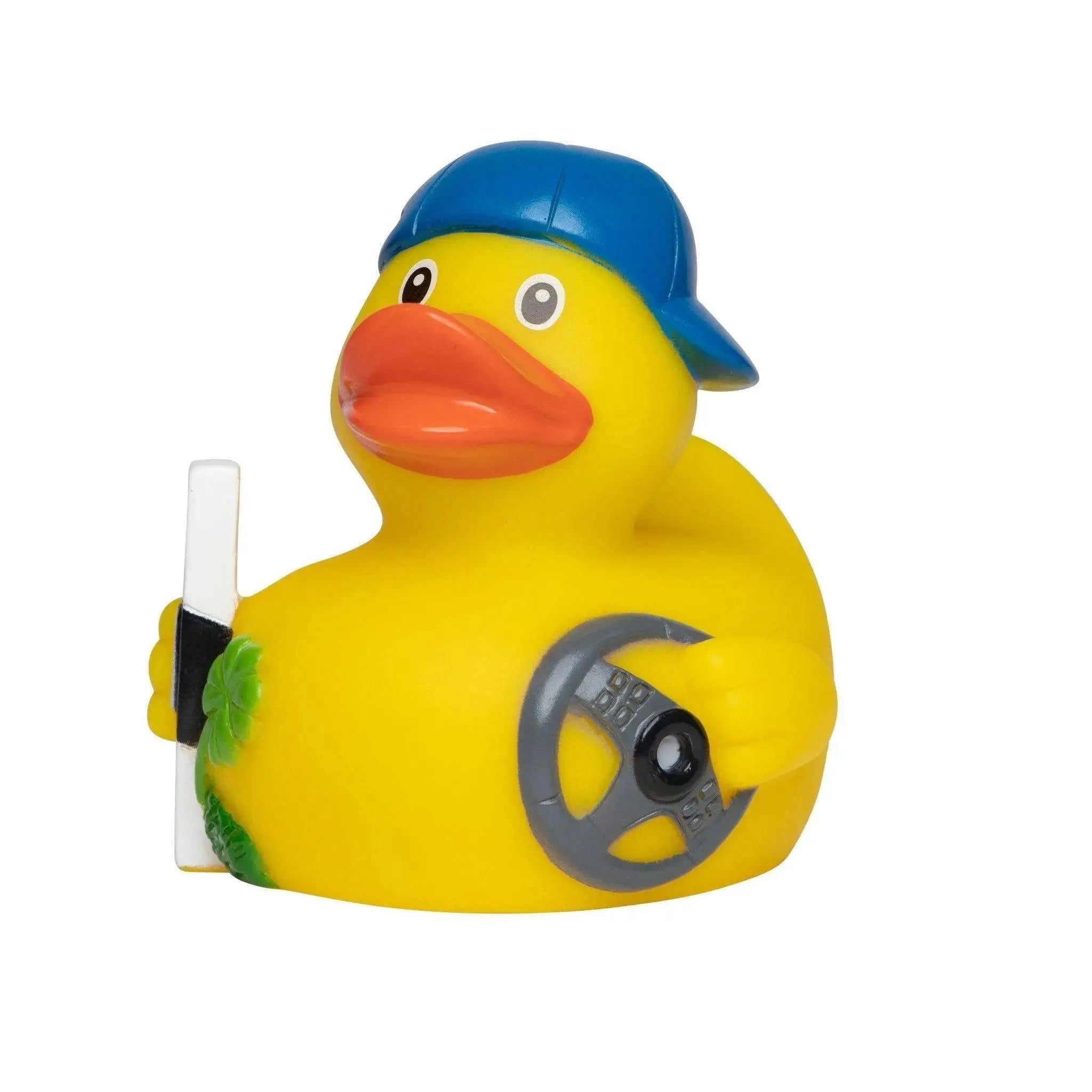 Gelbe badeente fahranfänger mit blauer kappe und steuer rad samt grünem blatt detail auf der seite