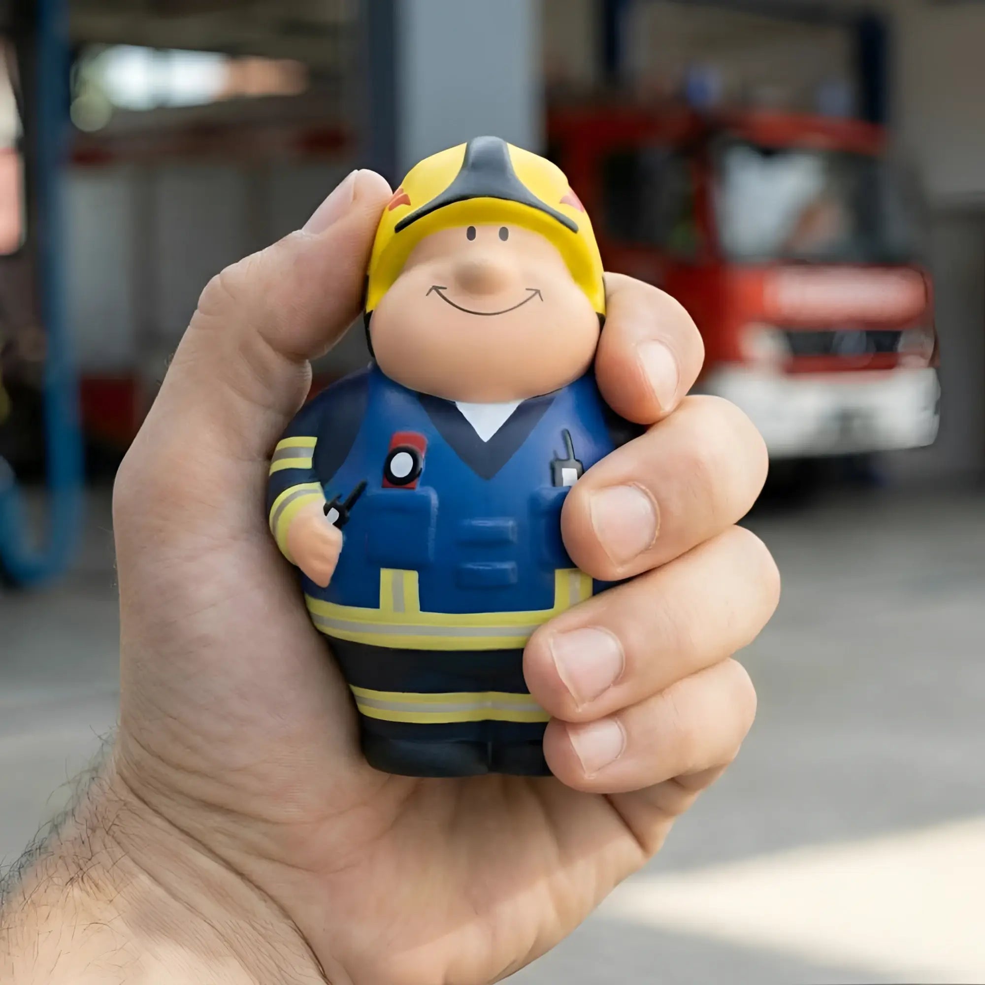 Gelb blaue feuerwehrmann stressball figur mit lächelndem gesicht und detaillierter uniform feuer bert 2.0