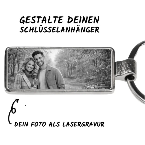 Rechteckiger silberner foto-schlüsselanhänger mit schwarz-weißer lasergravur eines lächelnden paares draußen