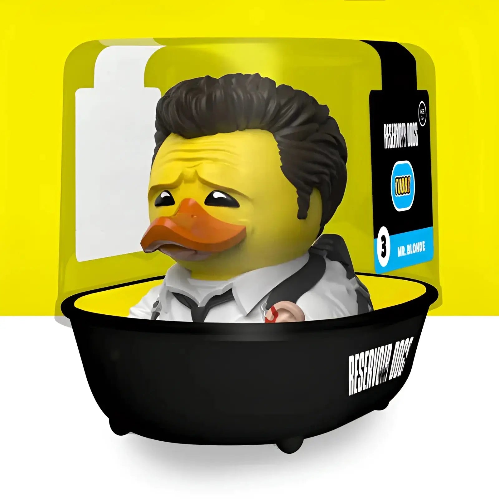 Gelbe gummiente mit schwarzen haaren und krawatte sitzt in schwarzer badewanne im geschenkset reservoir dogs tubbz