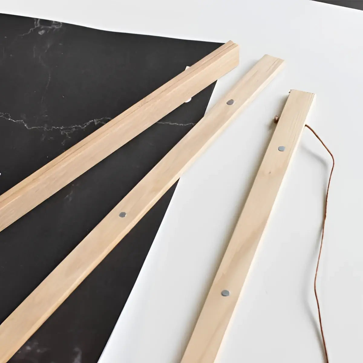 Hängender magnetrahmen für rubbelposter in hellholz mit vorgebohrten löchern und dünner brauner schnur