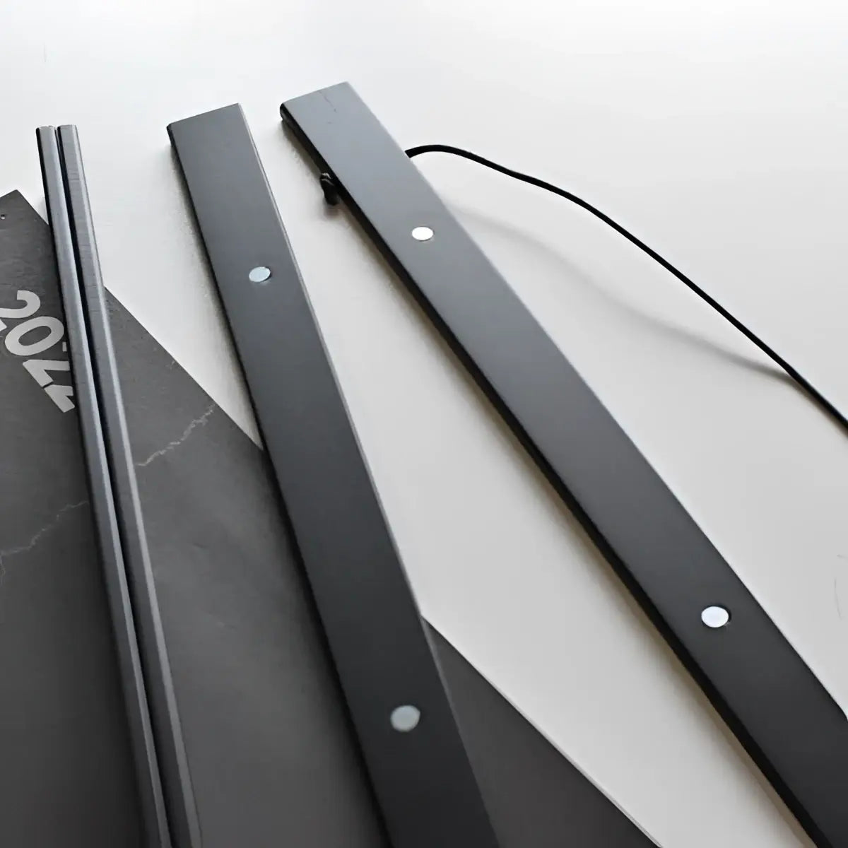 Hängender magnetrahmen für rubbelposter mit schwarzen magnetstreifen silbernen montageösen und schwarzem kordel am rückseite
