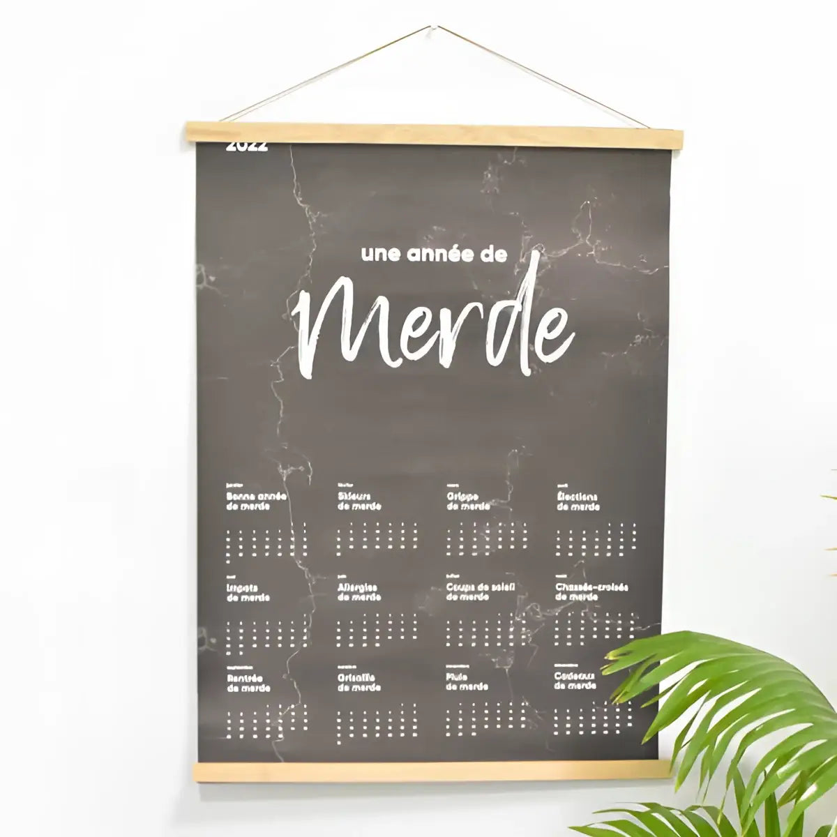 Hängender magnetrahmen aus hellem holz mit schwarzer marmor struktur und weißer weißer schrift für kalenderposter