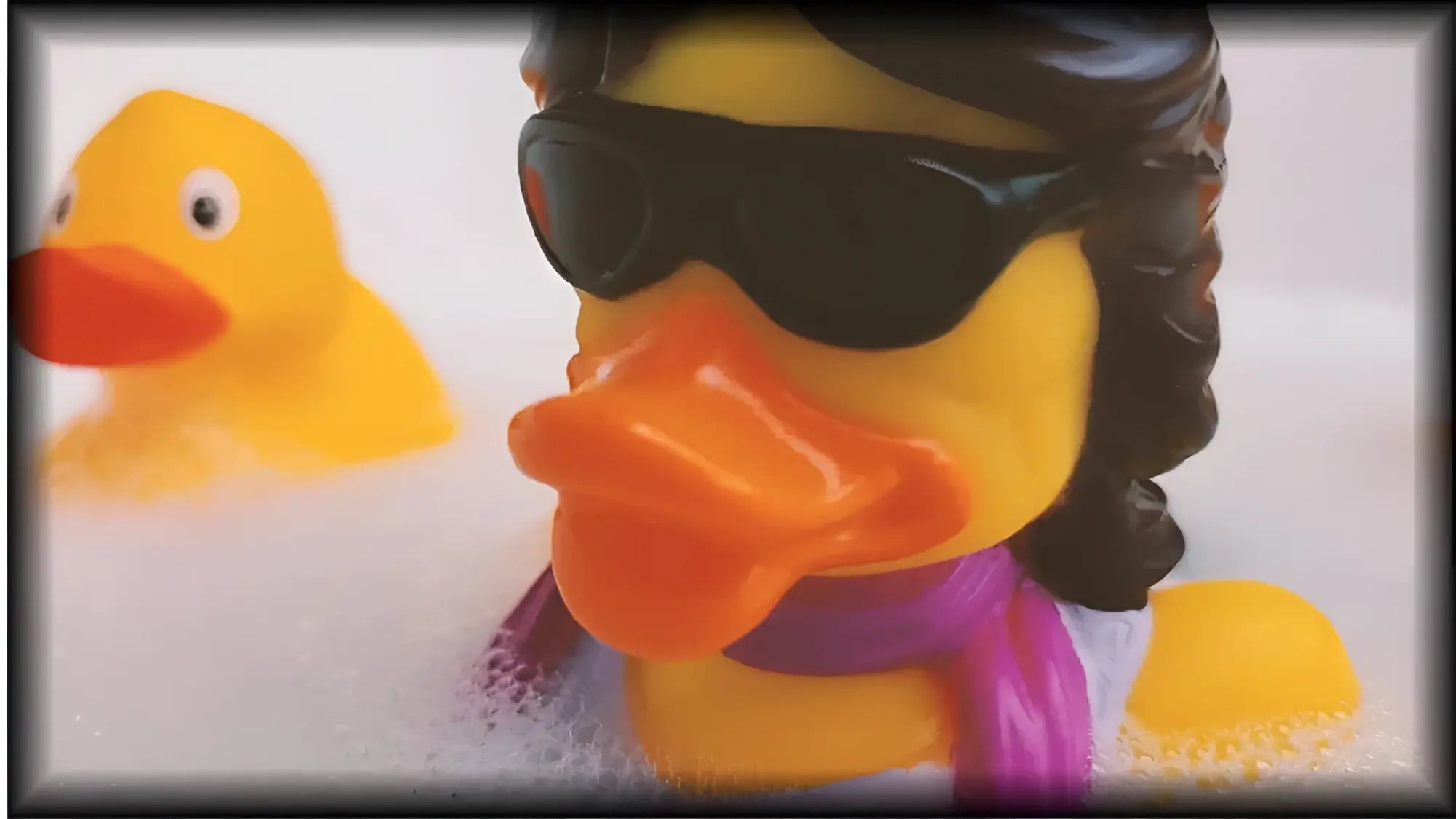 Gelbe gummiente jumpin quack splash mit schwarzen sonnenbrillen, lockigem haar und lila schal von celebri ducks