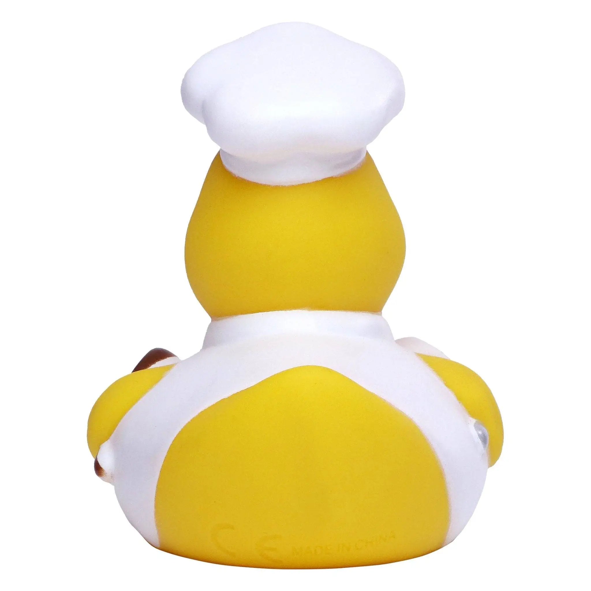 Gelbe badeente aus gummi mit weißer kochmütze und schürze als stille ente fürs badezimmer