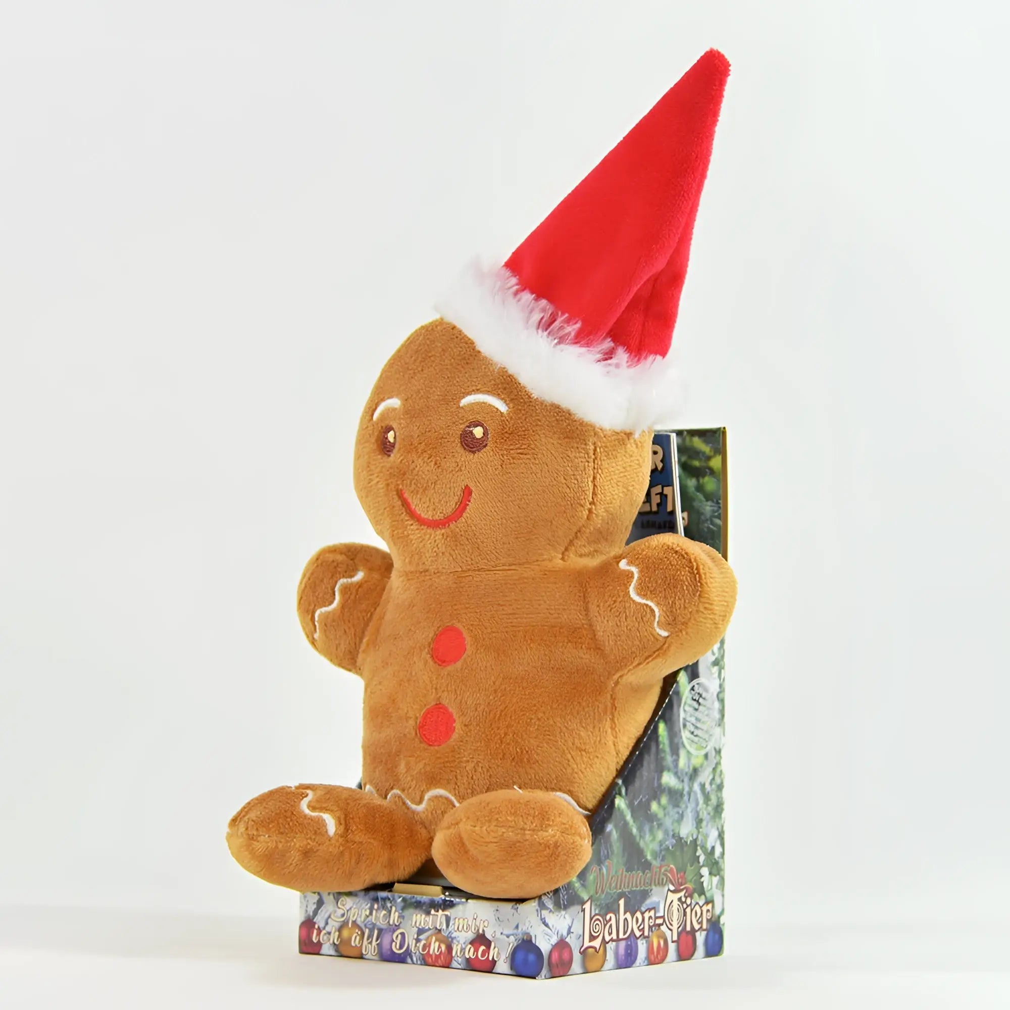 Ein plüsch-laber-lebkuchenmann ginny mit roter santa-mütze und besticktem gesicht sitzt aufrecht in der verpackung