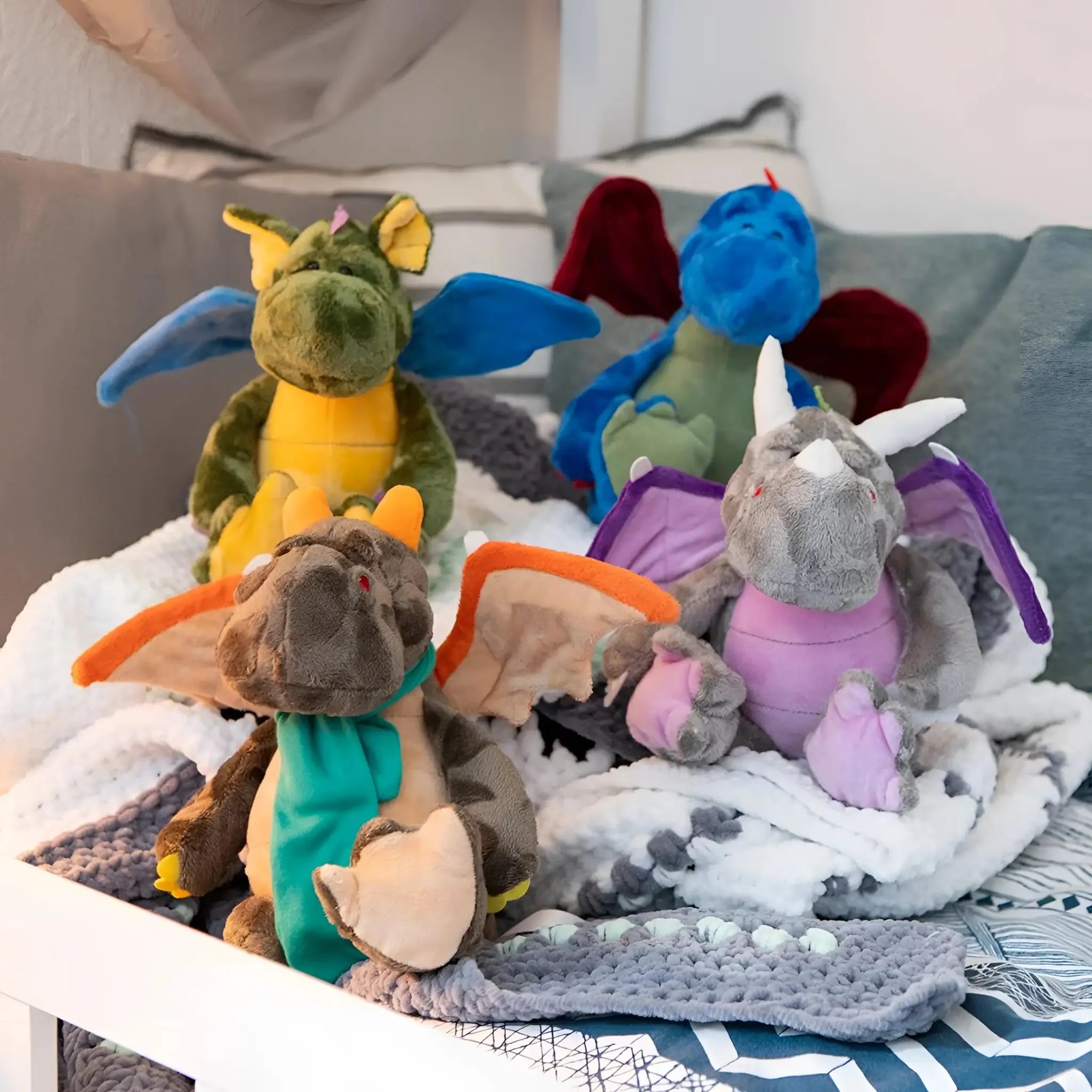 Ein kuscheliger miniFeet drache edda plüschtier stofftier mit grüner und gelber farbe sowie blauen flügeln geeignet ab 10 monate