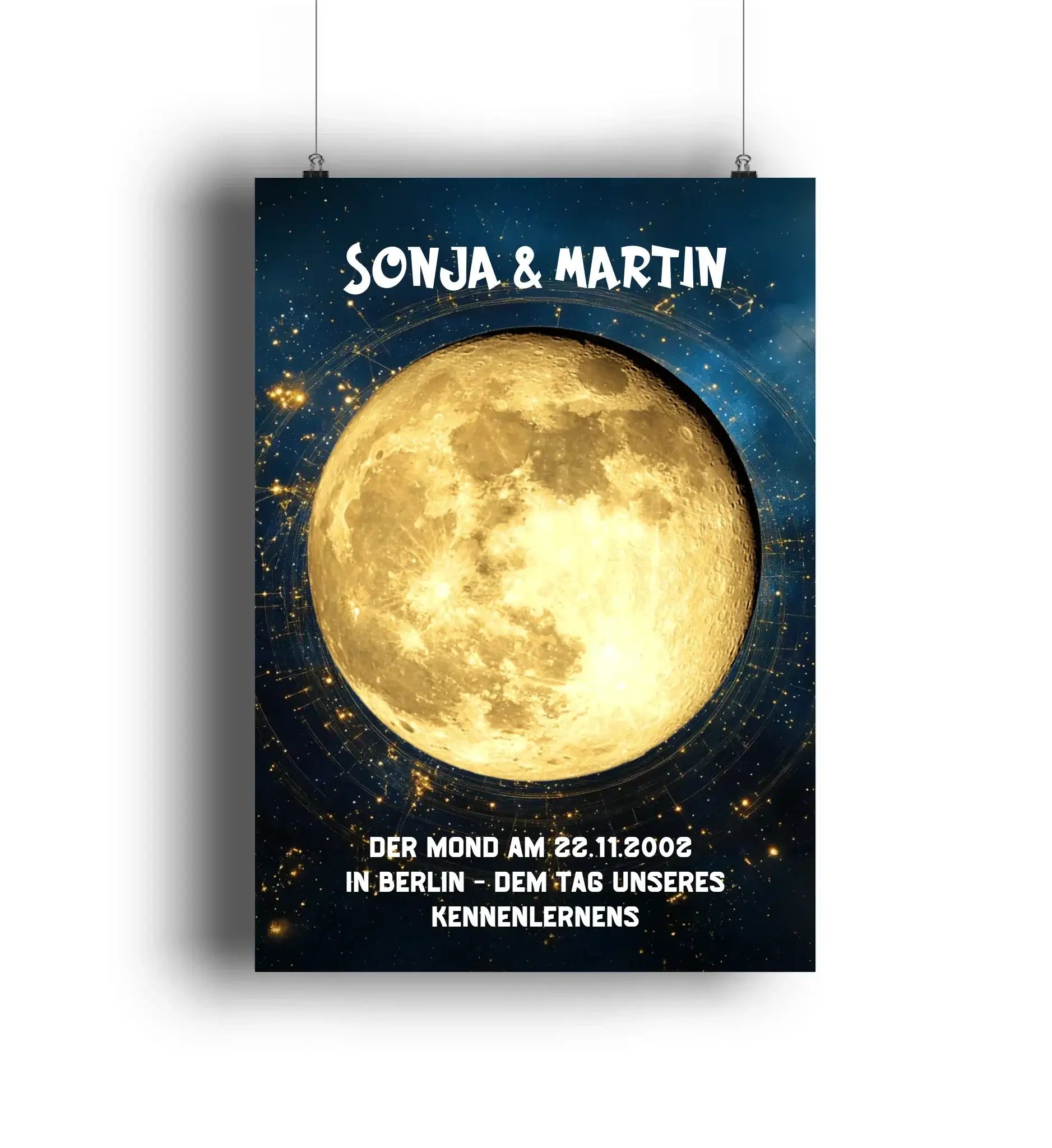 Ein goldfarbenes mondphasen poster mit weißem Text hängt an zwei schnüren vor einem dunklen sternenhimmel