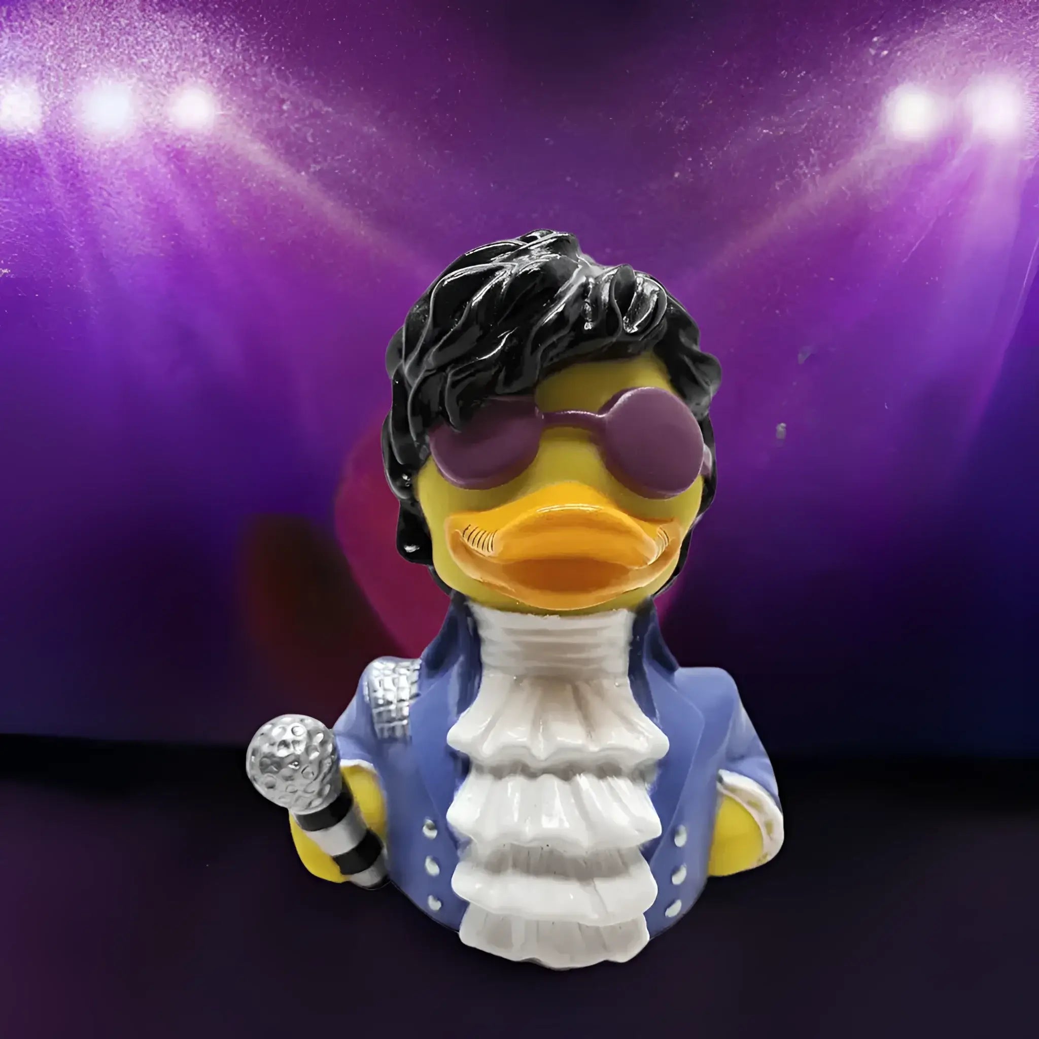 Gelbe gummiente als prinz mit schwarzer lockiger perücke lila sonnenbrille blaue jacke weißem rüschenkragen mikrofon paddle like it´s 1999 badeente von celebriducks