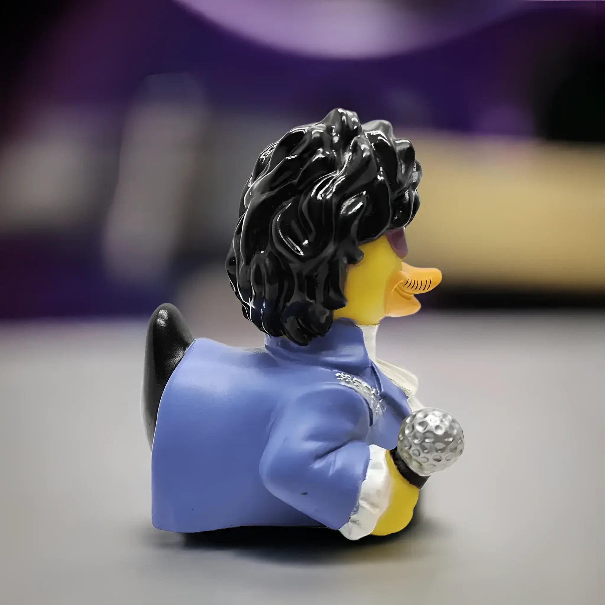Quietscheente gekleidet as prince mit glossy schwarz wig blau jacket und metallic microphone from celebri ducks paddle like it´s 1999 parody