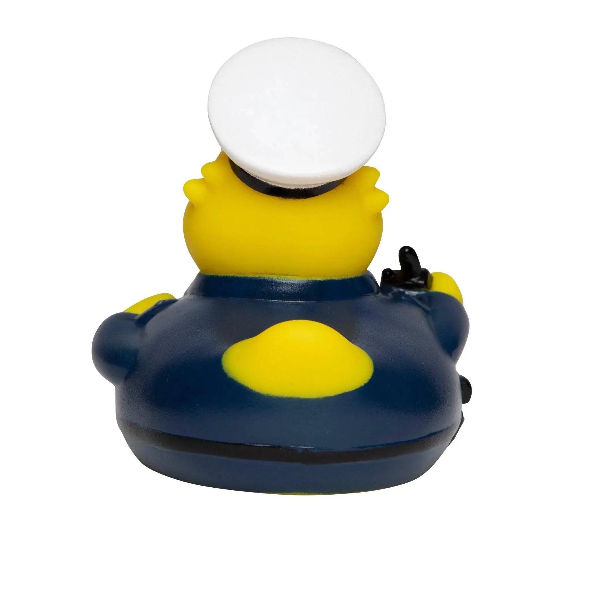 Gelbe quietsche-ente in polizist uniform mit weißem hut und gelbem abzeichen ideal zum baden
