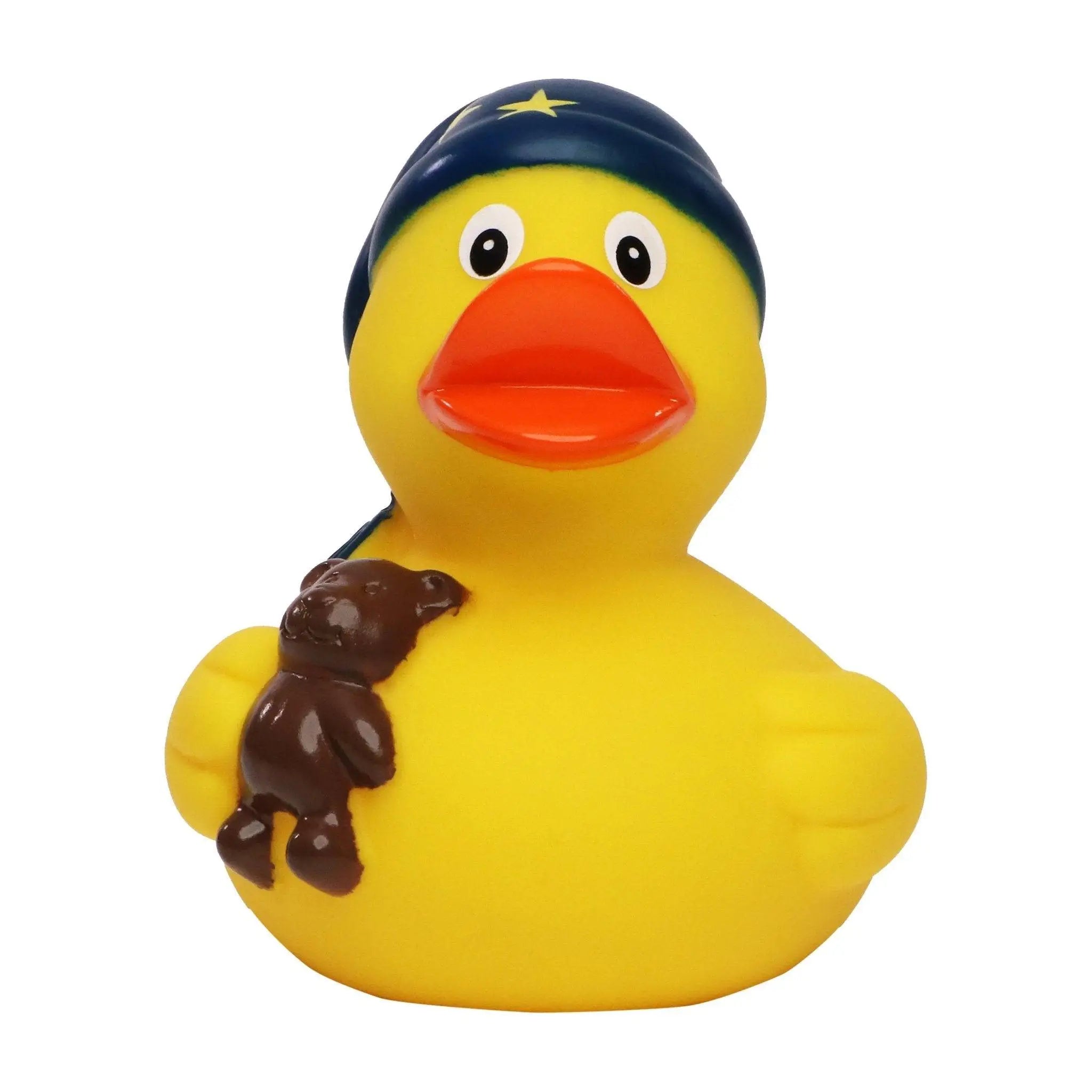 Gelbe badeente schlafmütze mit marineblauer mütze und gelbem stern hält braunen teddybären zum spielen
