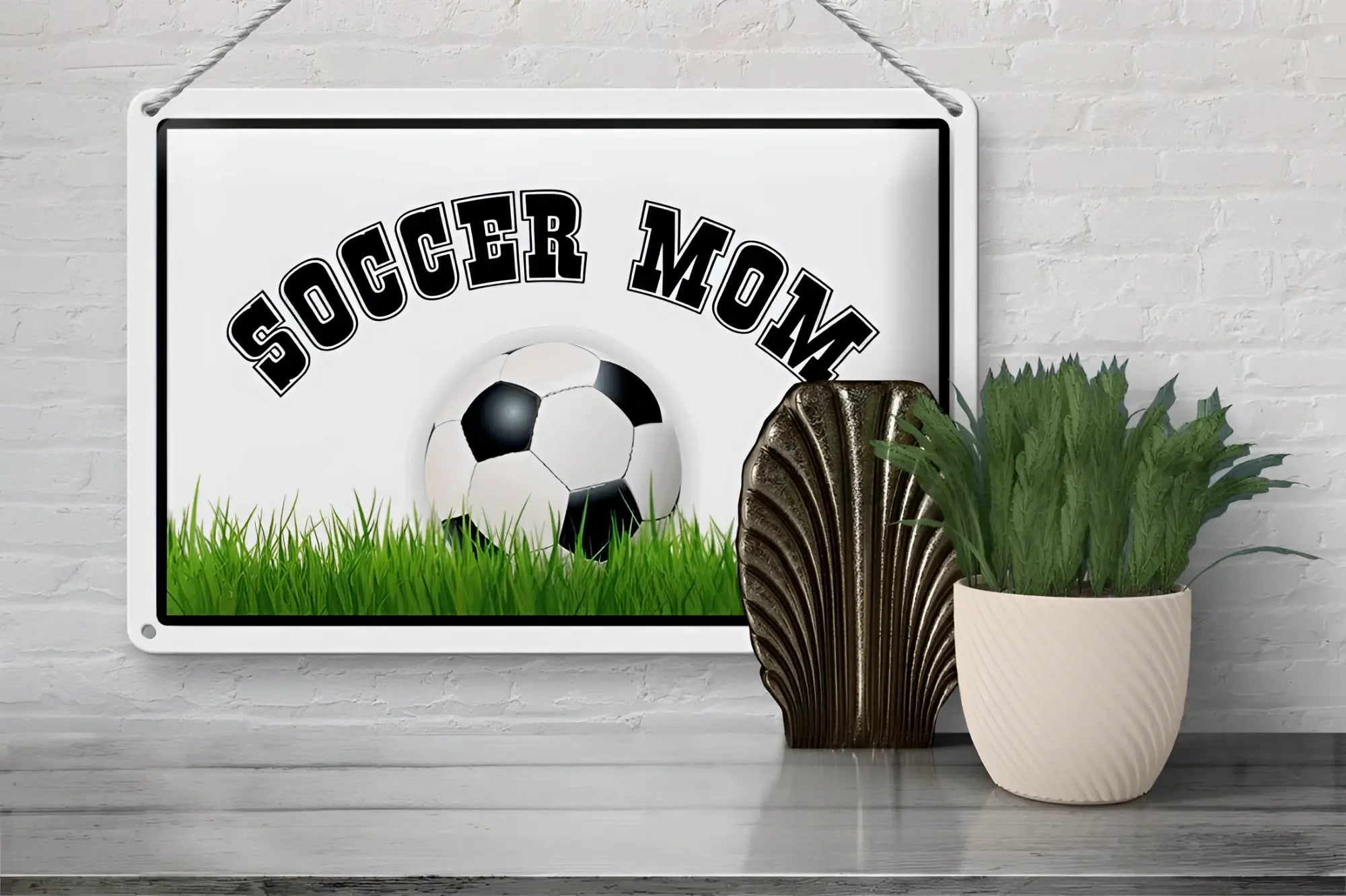 Weißes rechteckiges blechschild mit schwarzem soccer mom text und fußballmotiv auf grünem gras 20x30cm