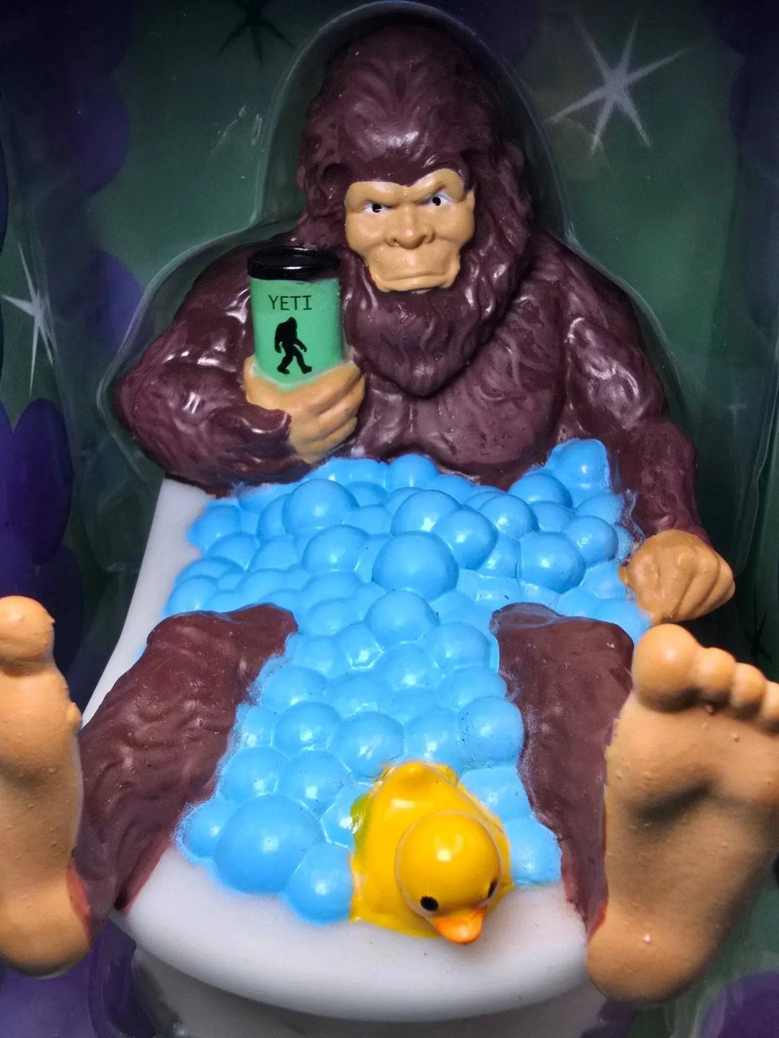 Spa-squatch gummiente von celebri-ducks lila plastik bigfoot mit grünem yeti tumbler im schaum bad mit gelber ente