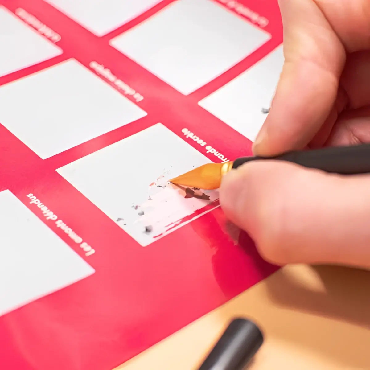 Roter kratzkalender mit weißen feldern und goldspitzem stift für kratzposter zum freirubbeln