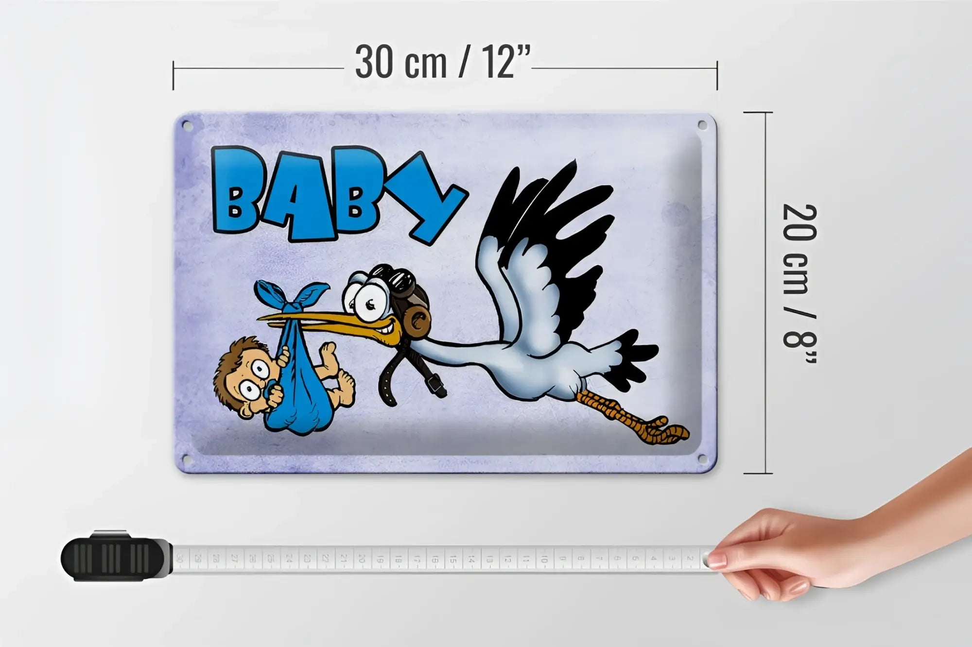 Rechteckiges blechschild 20x30cm mit cartoon-storch in blau und baby-schriftzug auf grauem hintergrund