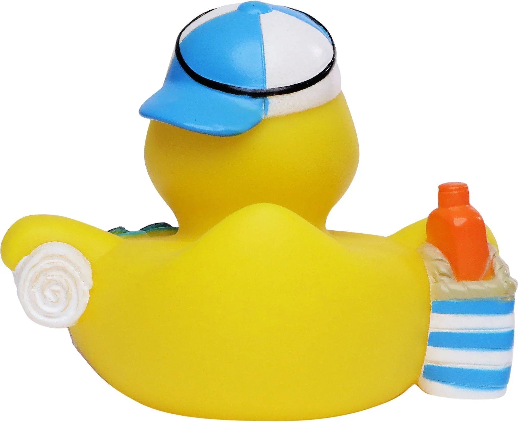 Gelbe quietsche-ente mit blau weißer baseballkappe hält orange flasche in gestreifter strandtasche für sommerurlaub