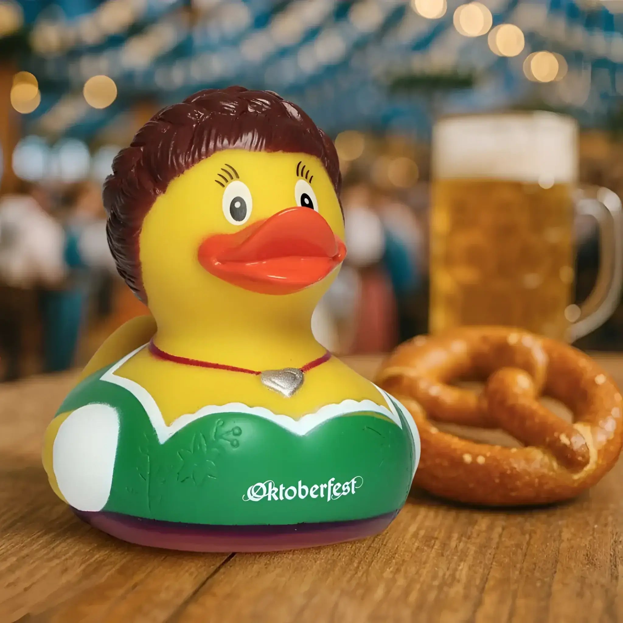 Gelbe badeente mit braunen haaren in grün weißem oktoberfest tracht kleid und silber herz halskette von schnabels