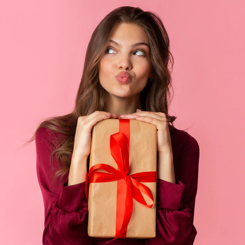 Ein braunes geschenkbox mit einer roten schleife aus der kollektion geschenke für frauen