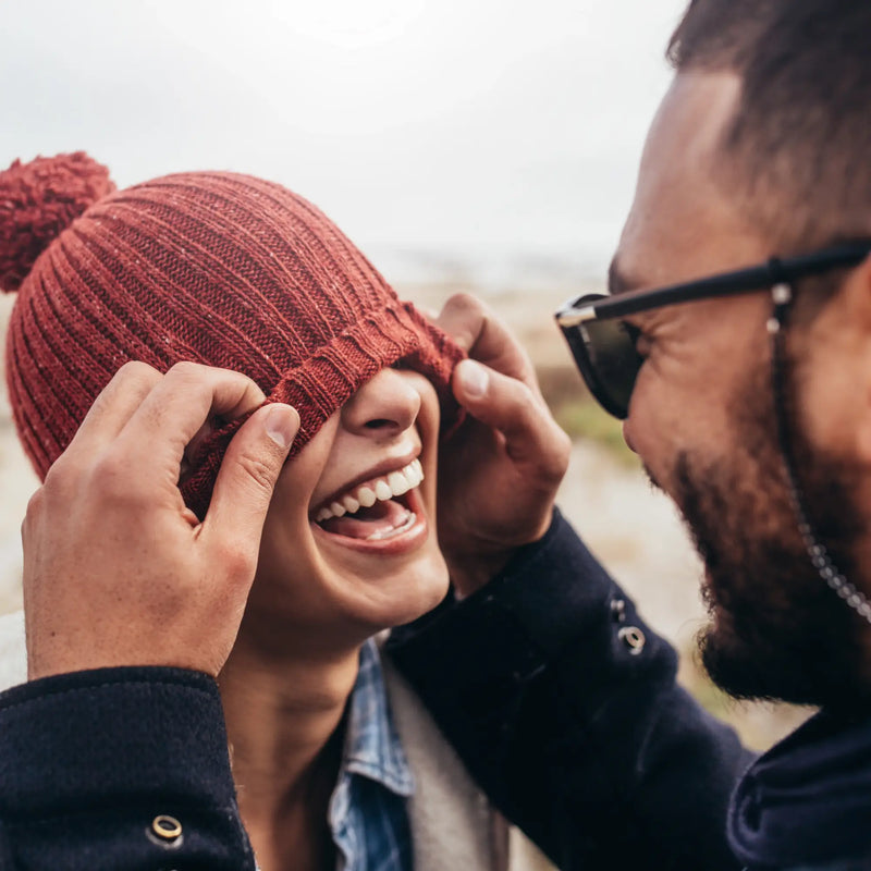 Eine kuschelige rote gerippte strickmütze mit flauschigem bommel aus der lustige geschenke kollektion