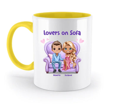 Weiße keramiktasse mit gelbem griff und innenleben sowie buntes cartoonmotiv von zwei liebenden auf lila sofa