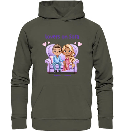 Olivegrüner kapuzenpullover mit cartoon von zwei figuren auf lila sofa und text lovers on sofa personalisierbar