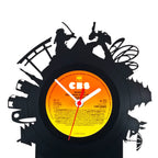 Schallplattentischuhr tokio aus schwarzer vinyl mit orangegelbem label und schatten von musikern plus schmetterling