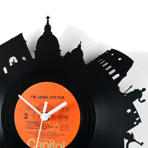 Schallplattenuhr rom aus schwarzer vinyl mit orangefarbenem ich bin jessi colter label und silhouetten von ikonischen gebäuden