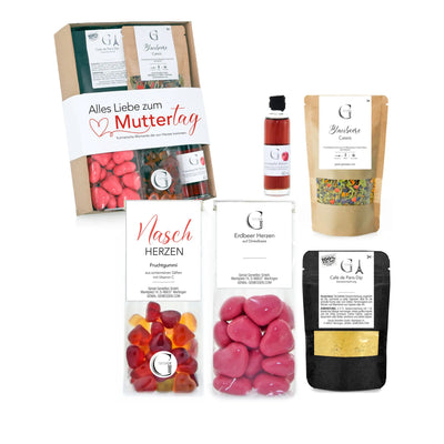 Ein geschenkset alles liebe zum muttertag mit einer box, rosa herzbonbons, roter flasche, kräutern und kaffeebechern