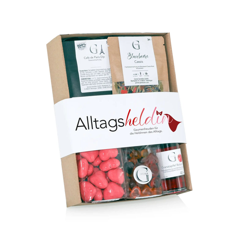 Ein beige karton geschenkset alltagsheldin mit weißen etikett und verschiedenen süßigkeiten und marmeladen im präsentkorb
