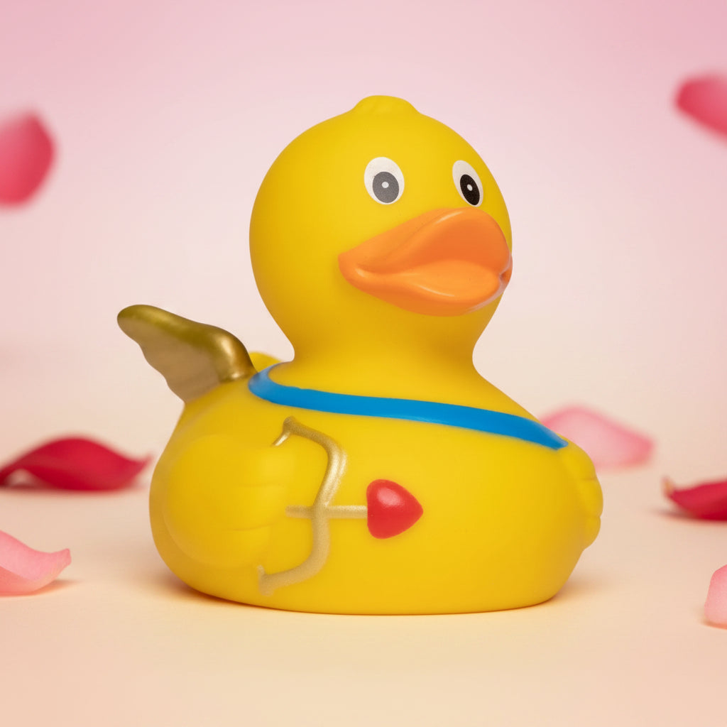Gelbe gummiente mit orangefarbenem schnabel, goldenen flügeln und herz-pfeil-design für amor und valentinstag