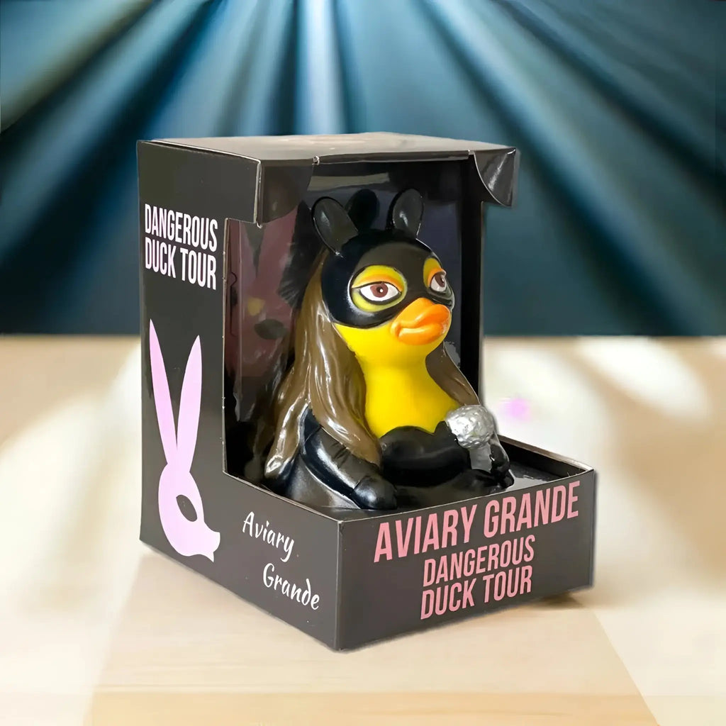 Gelbe gummiente im schwarzen superheldenmasken kostüm mit langem braunem haar und silbernem mikrofon von celebriducks