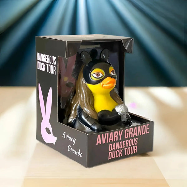 Gelbe gummiente im schwarzen superheldenmasken kostüm mit langem braunem haar und silbernem mikrofon von celebriducks