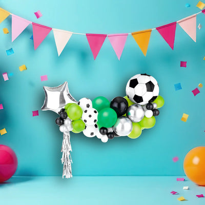 Ein fußball-themed ballonbogen aus grünen, schwarzen, weißen und silbernen luftballons mit fußballdruck