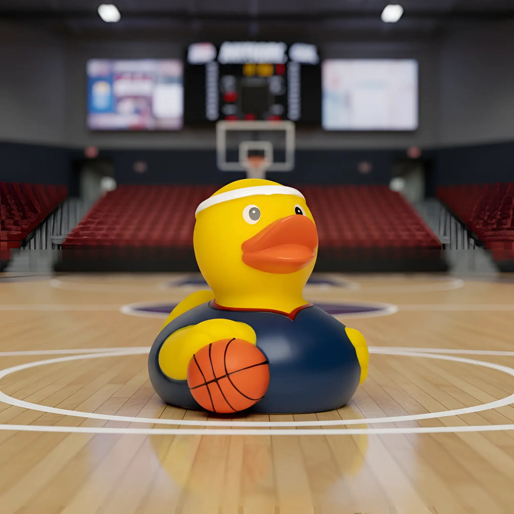 Gelbe quietsche-ente aus gummi mit navy basketball-trikot und orangefarbenem basketball für basketball-fans