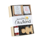 Ein beige gingerbread man geformtes candy aus klarem plastik in einer beschwipstes christkind geschenkbox mit festlicher verpackung