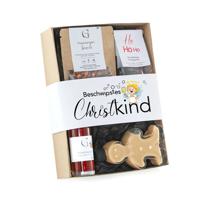 Ein beige gingerbread man geformtes candy aus klarem plastik in einer beschwipstes christkind geschenkbox mit festlicher verpackung