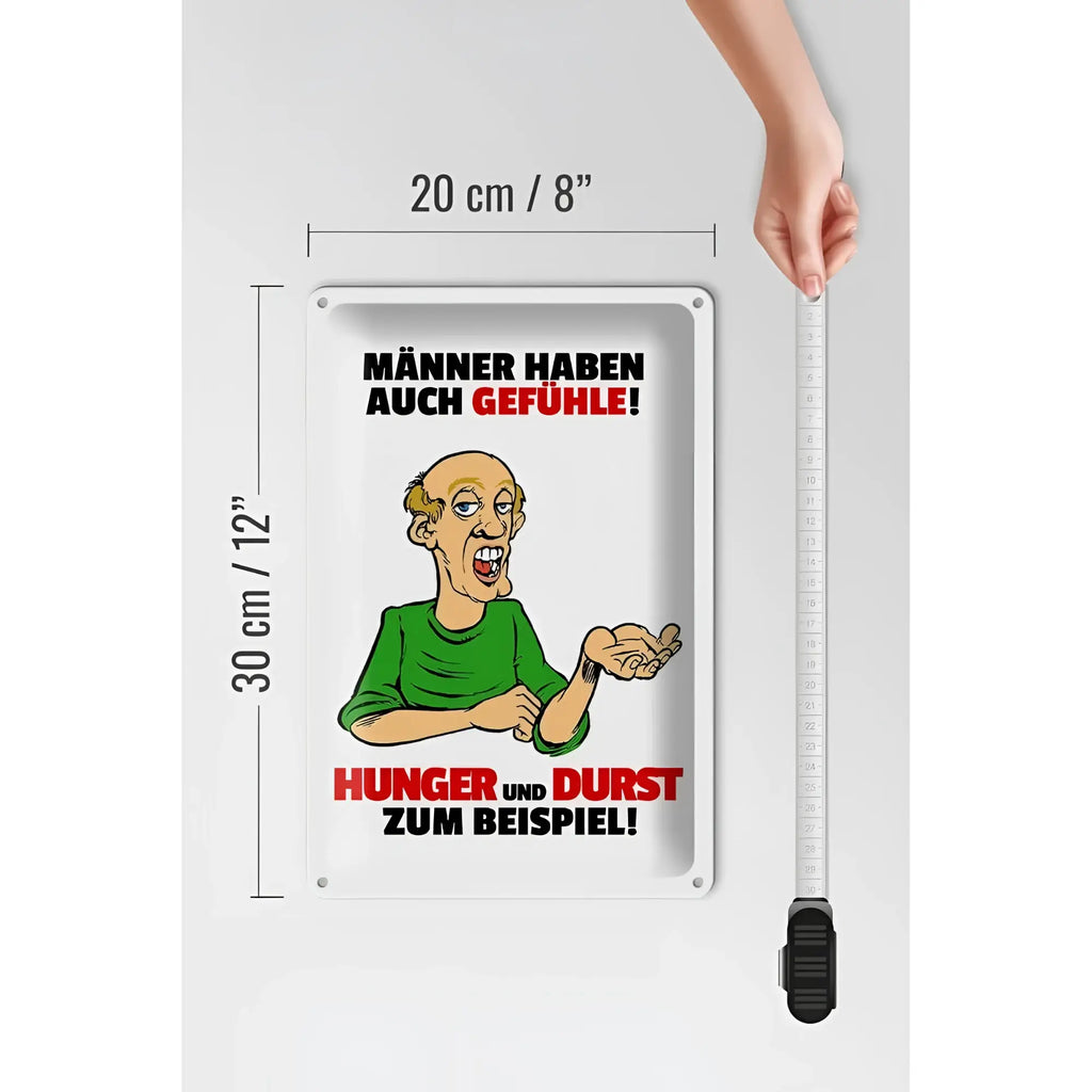 Weißes rechteckiges blechschild mit cartoon männerbild und schwarzem sowie rotem text männer haben auch gefühle