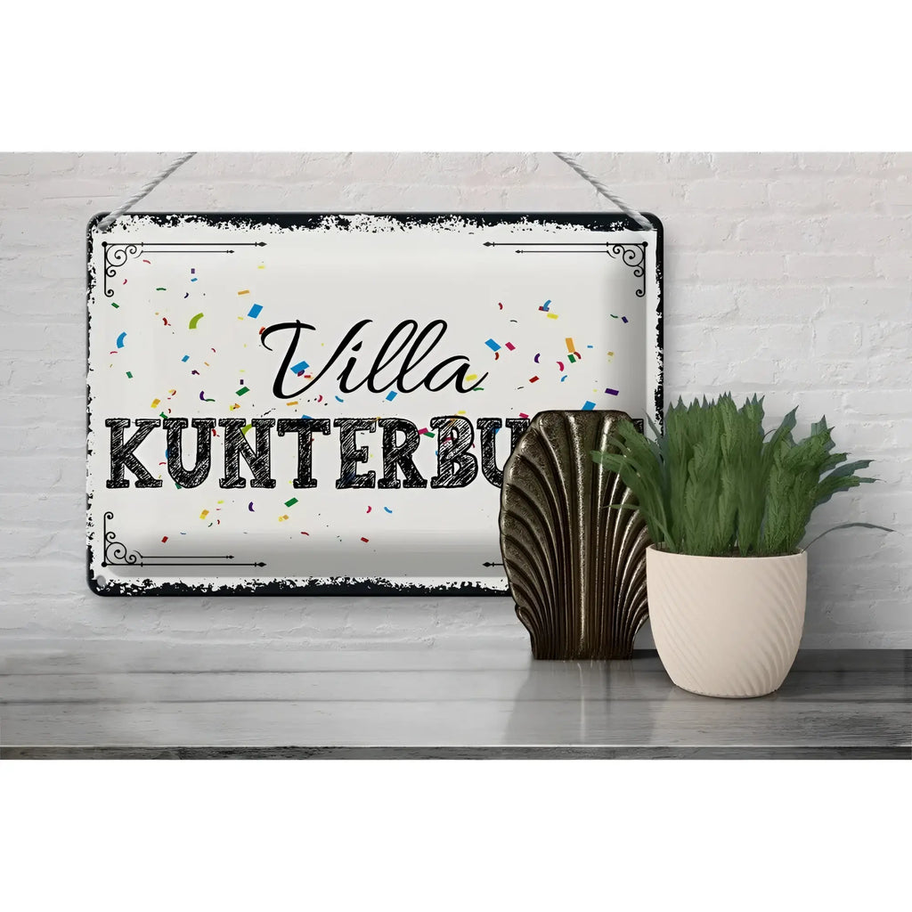 Weißes rechteckiges blechschild mit schwarzem vintage rand und villa kunterbunt schriftzug in buntem konfetti